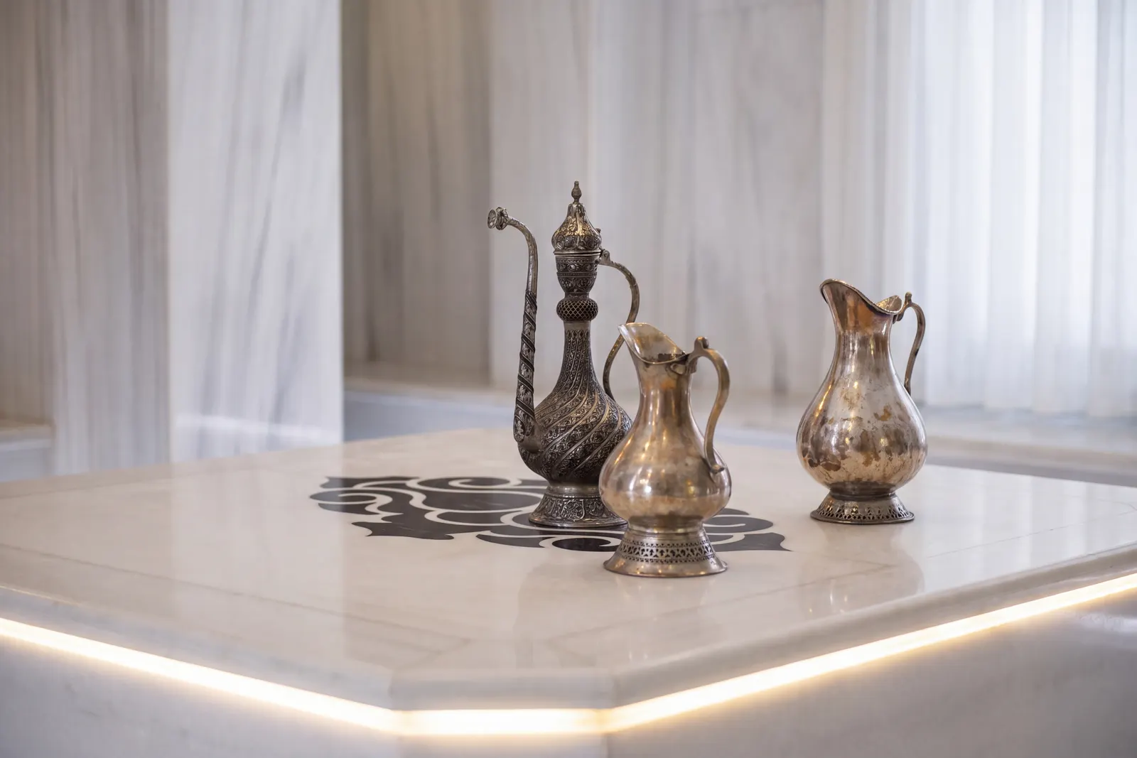 أباريق فضية على الرخام في حمام فرع Ramada Plaza